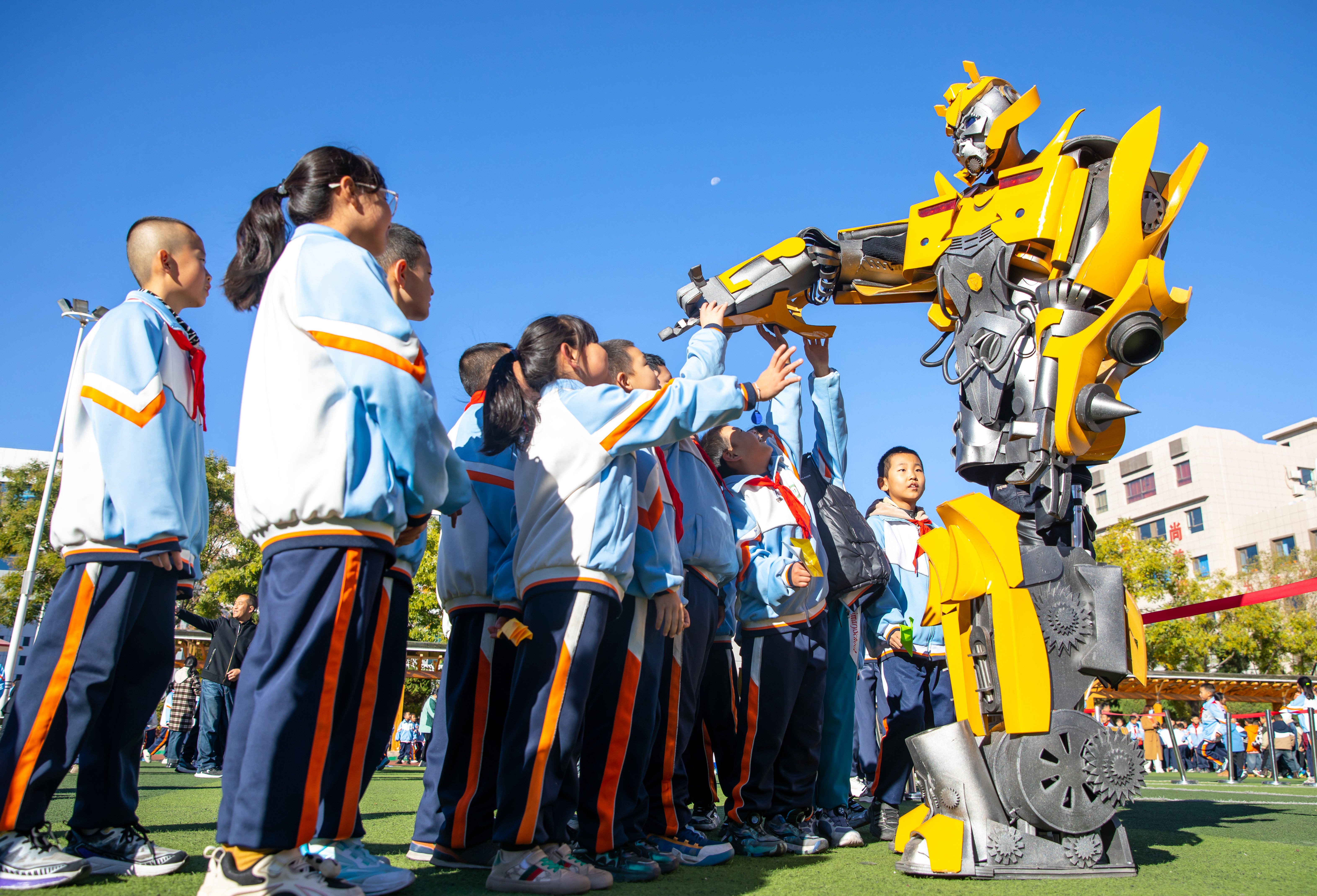 2024年10月22日，在甘肅省張掖市甘州區(qū)北街街小學(xué)科技大篷車(chē)嘉年華活動(dòng)上，學(xué)生與“大黃蜂”機(jī)器人互動(dòng)。楊瀟 攝.jpg