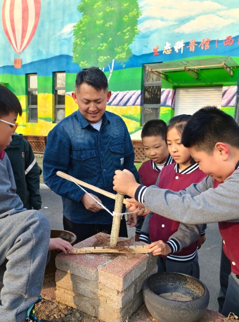 沈撫育才實(shí)驗學(xué)校老師給學(xué)生們講解鉆木取火的科學(xué)原理.jpg